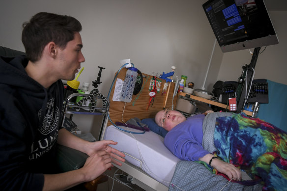 Josh Van Dijk and Ricky Buchanan in Buchanan’s Balaclava home. Ricky is bedridden (she has chronic fatigue syndrome) and must stay in a hospital bed all day.