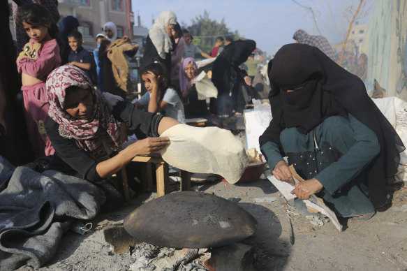 Palestinian women bake bread outside a UN-run school in Rafah, Gaza.