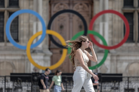 A woman passes by the Olympic rings at the City Hall in Paris. Latvia and 34 other countries are threatening to boycott next year’s olympics if athletes from Russia and its ally Belarus are allowed to take part.