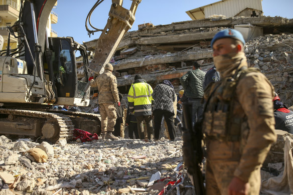 Rescue workers stand on a collapsed building in Adiyaman, southern Turkey.