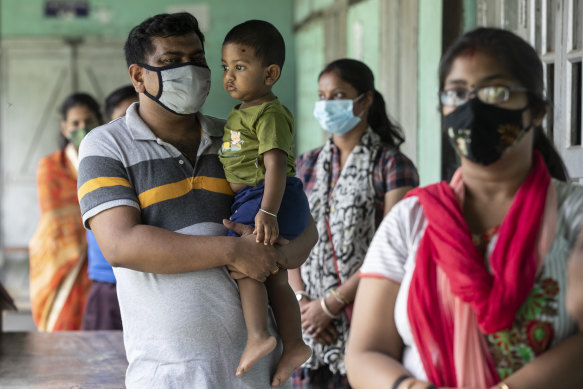 People above 18 years age queue up to get vaccinated against the coronavirus in Assam, India on Monday.