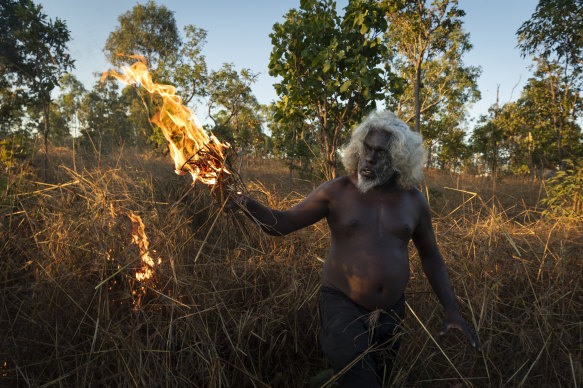 Nawarddeken elder Conrad Maralngurra burns grass to protect the Mamadawerre community from late-season wildfires.