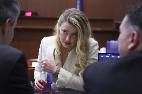 Amber Heard talks to her lawyers during the hearing.