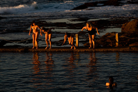 After viewing the sunrise,  a group of swimmers dive into Mahon Pool at Maroubra, on the last day of winter, in Sydney. 