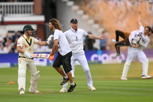 Ben Stokes of England and David Warner of Australia attempt to stop a “Just Stop Oil” protester.