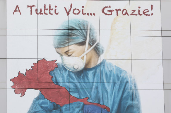 A mural on the side of a building in Lombardy thanks medical workers. 
