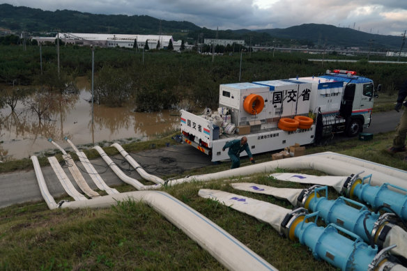 Water pumps drain flooding from a breached levee in Naganuma, near the city of Nagano in Japan.