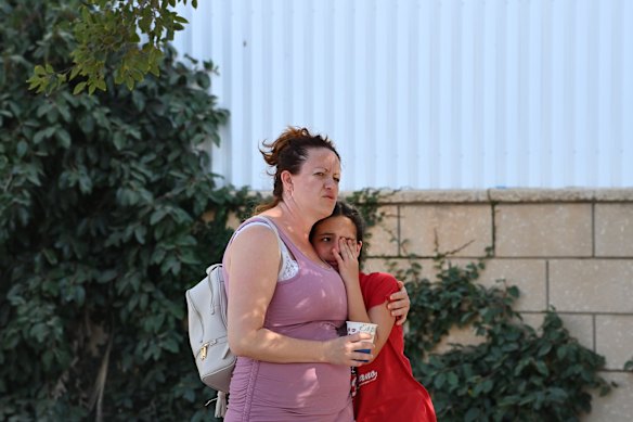 A woman comfort a girl outside a flat building that has been struck by an iranian ballistic missile in beersheba on Tuesday.