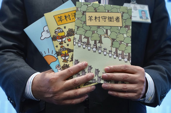 A police superintendent poses with the children’s books, in which sheep have to deal with wolves from a different village, that were used as evidence against the five speech therapists.