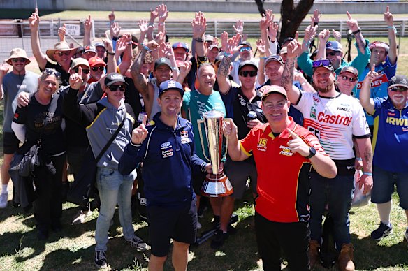 Fans surround 2006 Bathurst 1000 winners Jamie Whincup and Craig Lowndes, who hold the Peter Brock Trophy.