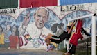 Girls play next to a mural of the late Pope Francis in Buenos Aires, Argentina. 