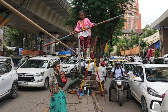 A girl walks a tightrope as she performs for money in Mumbai, India.