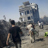 Palestinians evacuate from a site hit by an Israeli bombardment on Khan Younis, southern Gaza Strip on July 13.