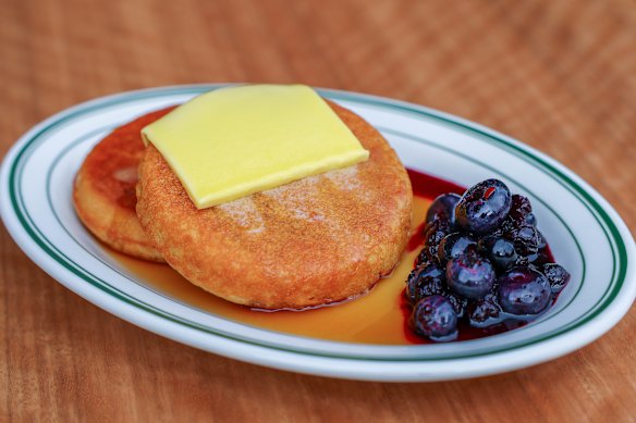Pancakes are thick and served with butter, blueberry compote and maple syrup.