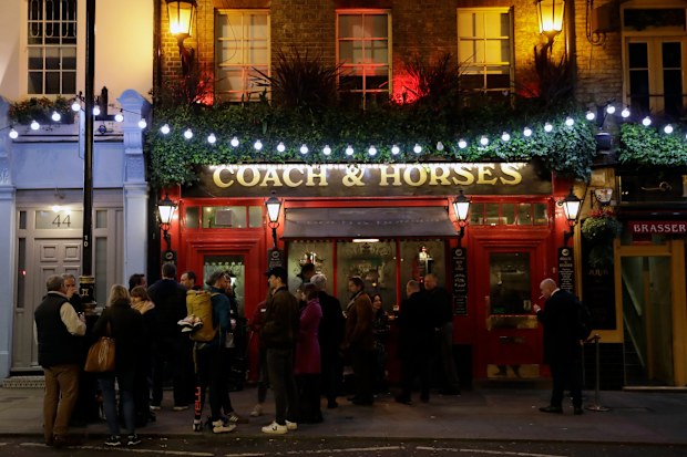 People drinking outside a pub in Soho, London