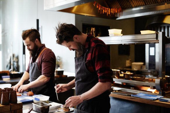 Aaron Turner (right) with the fire that has been central to the cooking at Igni.