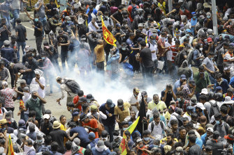 Sabato (AEST) i manifestanti hanno reagito quando un proiettile lacrimogeno sparato dalla polizia è caduto accanto a loro a Colombo, Sri Lanka.