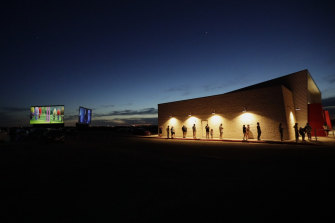 Using social distancing practices, moviegoers wait in line at the concession stand at the Stars and Stripes Drive-In Theatre that reopened in New Braunfels, Texas.