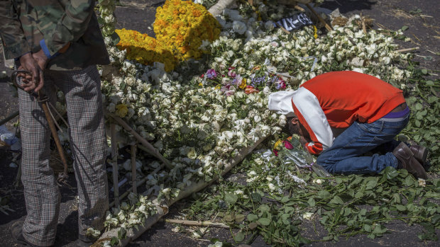 An Ethiopian relative of a crash victim mourns and grieves next to a floral tribute at the scene where the Ethiopian Airlines Boeing 737 Max 8 crashed shortly after takeoff on March 15.
