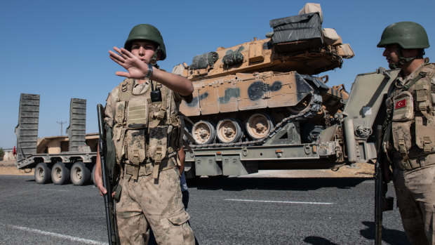 Turkish military vehicles carry tanks to the Syrian border on October 12, 2019.