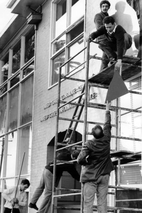 Workmen start repairing the damage from the demonstration at the U.S. consulate.