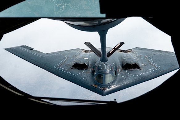 A B-2 Spirit stealth bomber flies behind a KC-135 Stratotanker during a commemorative flight in June 2023.