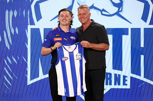 Lachy Dovaston, pick 16, poses with North Melbourne legend Glen Archer. 