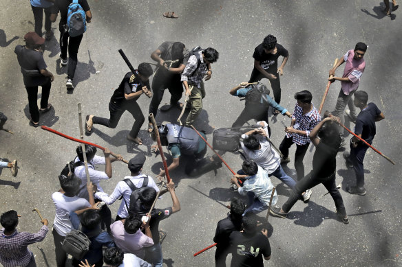 Students attack a policeman in Dhaka.