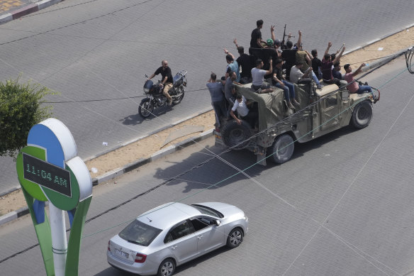 Hamas militants drive a captured Israeli military vehicle in Gaza City at the weekend.