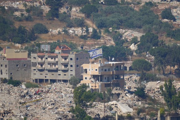 An Israeli flag flies over a destroyed building in southern Lebanon on Sunday.