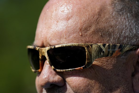 Sweat runs down the face of Robert Harris as he digs fence post holes in Houston.