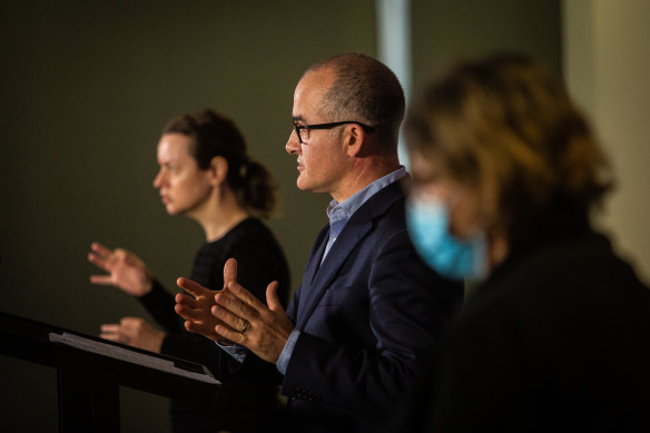 Victorian Education Minister James Merlino (centre) addresses the media.