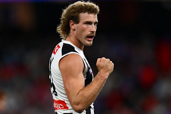 Angus Anderson of the Magpies celebrates kicking a goal.
