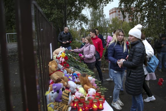 People gather to lay flowers and toys and light candles after the shooting at school No. 88 in Izhevsk, Russia.