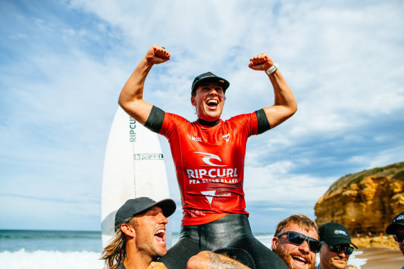 Tyler Wright being chaired up the beach by her brothers Owen and Mikey after her Bells Beach triumph last year.