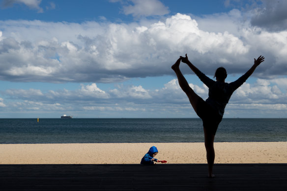 A woman exercises near St Kilda beach.