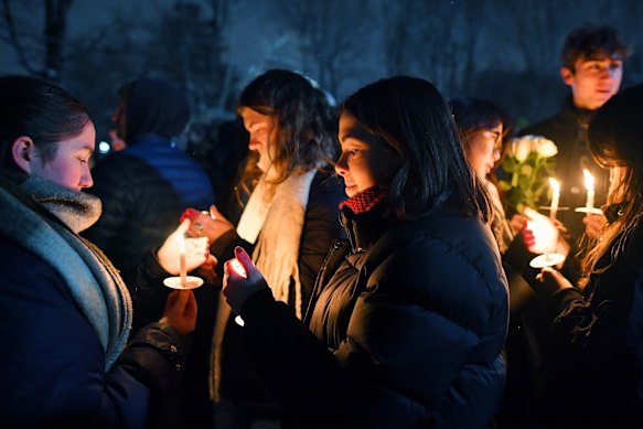 People hold candles during a vigil in Providence for the victims.