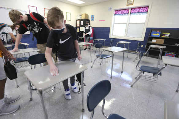 Zach Lee, an eighth grader at Guntown Middle School, sanitises a desk as he and other students enter their maths class on the first day back to school for the Lee County District in Guntown, Mississippi, last week. 