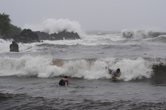 Surfers at Punalu’u Beach, Hawaii, on Saturday weren’t deterred by Hurricane Nolo which still poses a risk of flash floods, dangerous winds and extreme surf.