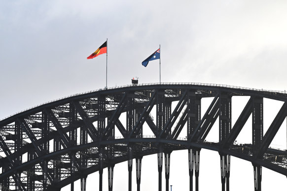 The Australian national and Aboriginal flags fly together on the Sydney Harbour Bridge on Australia Day. 