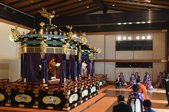 Naruhito, left, delivers his speech as Masako, second from left, Prime Minister Shinzo Abe, right, and other officials attend the enthronement ceremony.