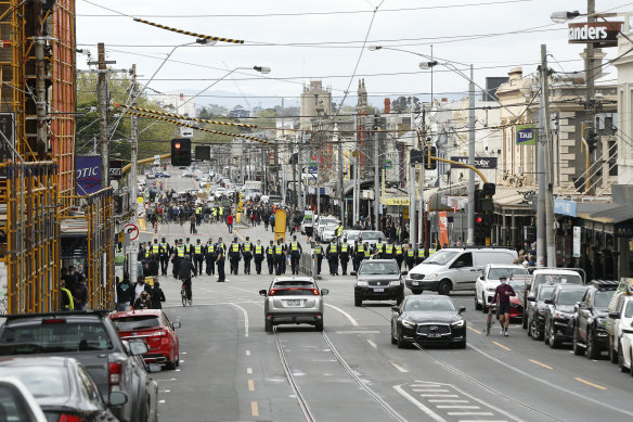 Police in a line approaching protesters on Bridge Road, Richmond.