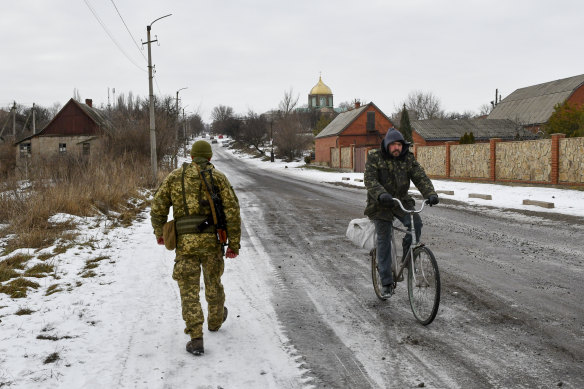 A Ukrainian soldier patrols a street in a village in the Donetsk region, near the front line of the Donbas conflict.