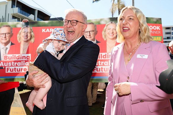 Anthony Albanese cuddles a child next to Labor candidate for Bonner in Brisbane, Kara Cook.