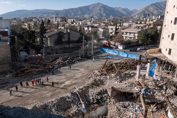 Pekerja darurat menilai bangunan yang hancur di lingkungan Shahrak-e Ghard.