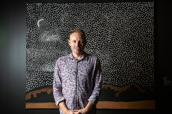 Luke Scholes, curator of Aboriginal Art and Material Culture, Museum and Art Gallery of Northern Territory,  in front of artwork 'Garnkiny' 2019, by Rusty Peters. The artwork won the People's Choice Award.