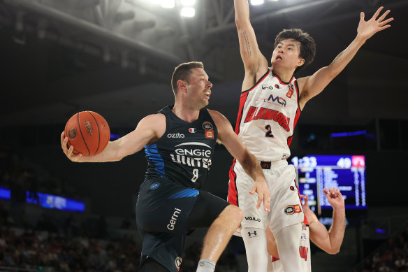 Matthew Dellavedova dishes off a pass under pressure from Hawk Hyunjung Lee.