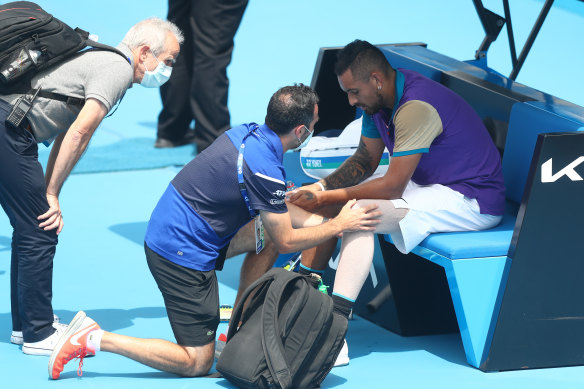A physiotherapist assess Nick Kyrgios’ knee during a break in his match against Borna Coric of Croatia at Melbourne Park.