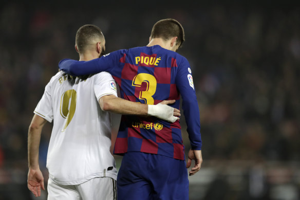 Real Madrid's Karim Benzema (left) and Barcelona's Gerard Pique walk off the pitch together after the draw.