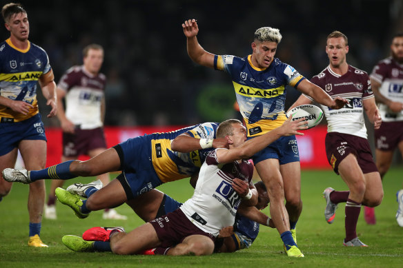 Tom Trbojevic of the Sea Eagles attempts to pass around Dylan Brown.